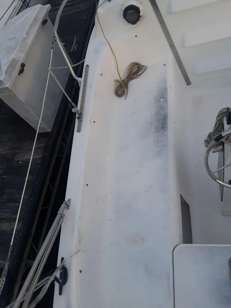 Slide: The Image of 1996 MacGregor 26 "X" sailboat deck with ropes and fittings. - 14