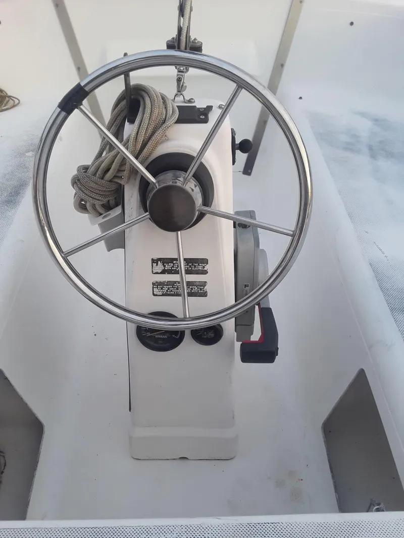 Slide: The Image of Steering wheel of a 1996 MacGregor 26 "X" sailboat with control panel and rope. - 15