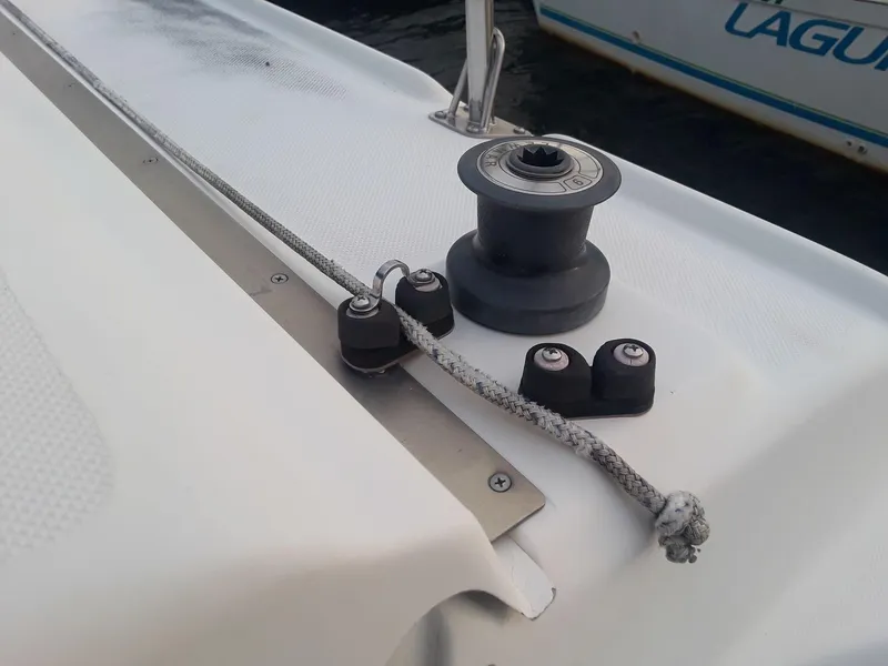 Slide: The Image of 1996 MacGregor 26 "X" sailboat deck with winch and rope cleats. - 26