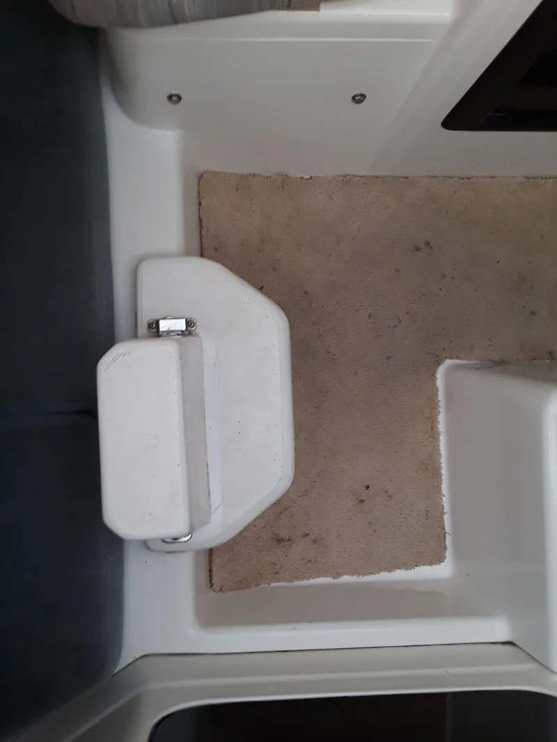 Slide: The Image of Interior view of a 1996 MacGregor 26 "X" sailboat, featuring a compact step and carpeted floor. - 27