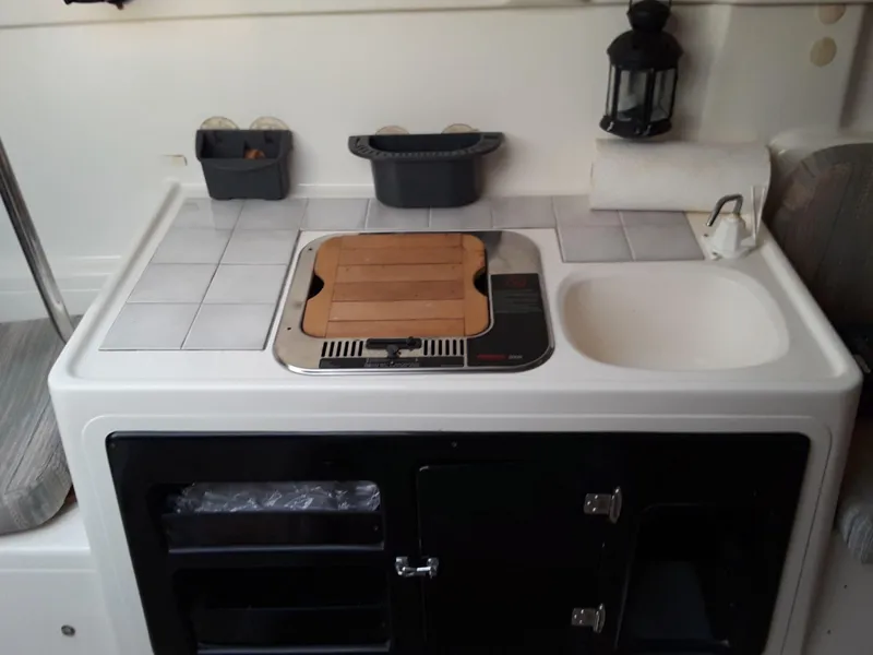 Slide: The Image of Compact kitchen area in a 1996 MacGregor 26 "X" sailboat with stove and sink. - 28