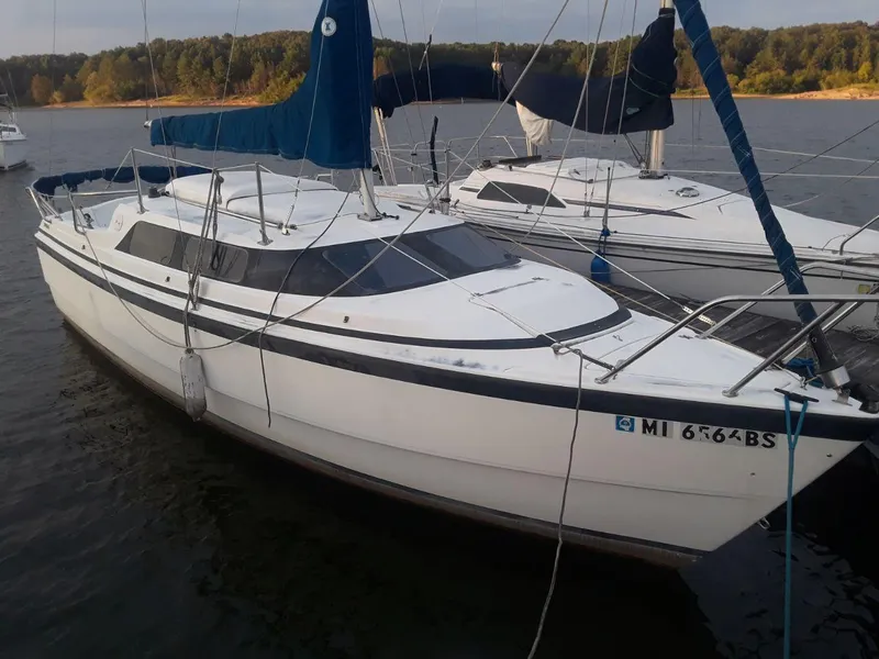 Slide: The Image of 1996 MacGregor 26 "X" sailboat docked on calm water. - 3