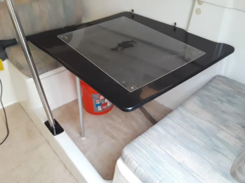 Slide: The Image of Interior of 1996 MacGregor 26 "X" sailboat with table and seating area. - 31