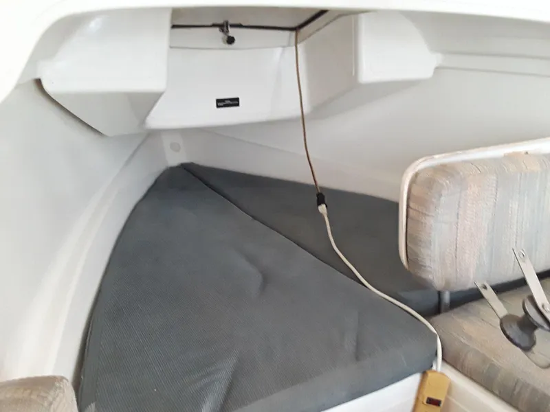 Slide: The Image of Interior cabin of a 1996 MacGregor 26 "X" sailboat, featuring seating and storage. - 34