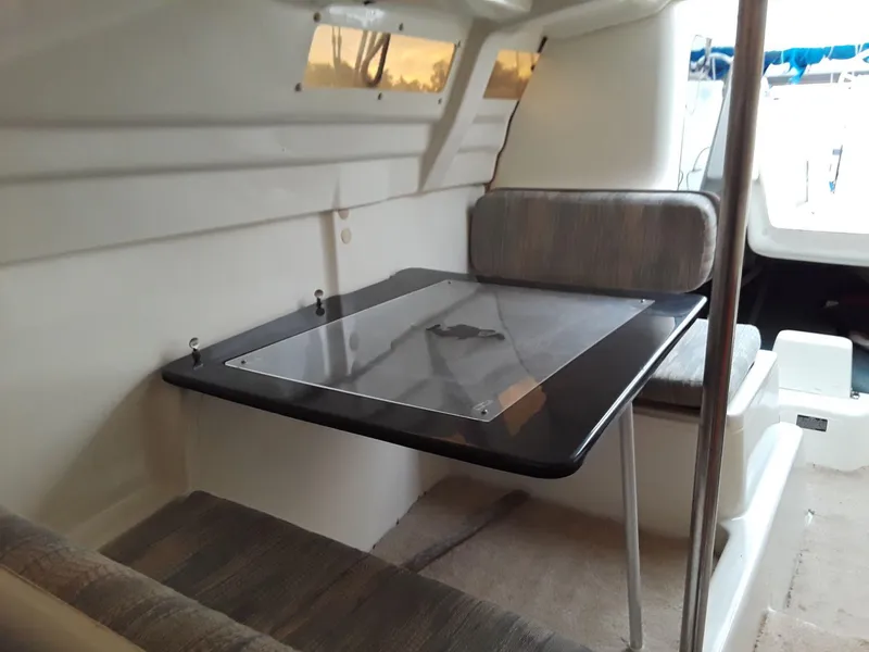 Slide: The Image of Interior of a 1996 MacGregor 26 "X" sailboat with a compact dining area. - 37