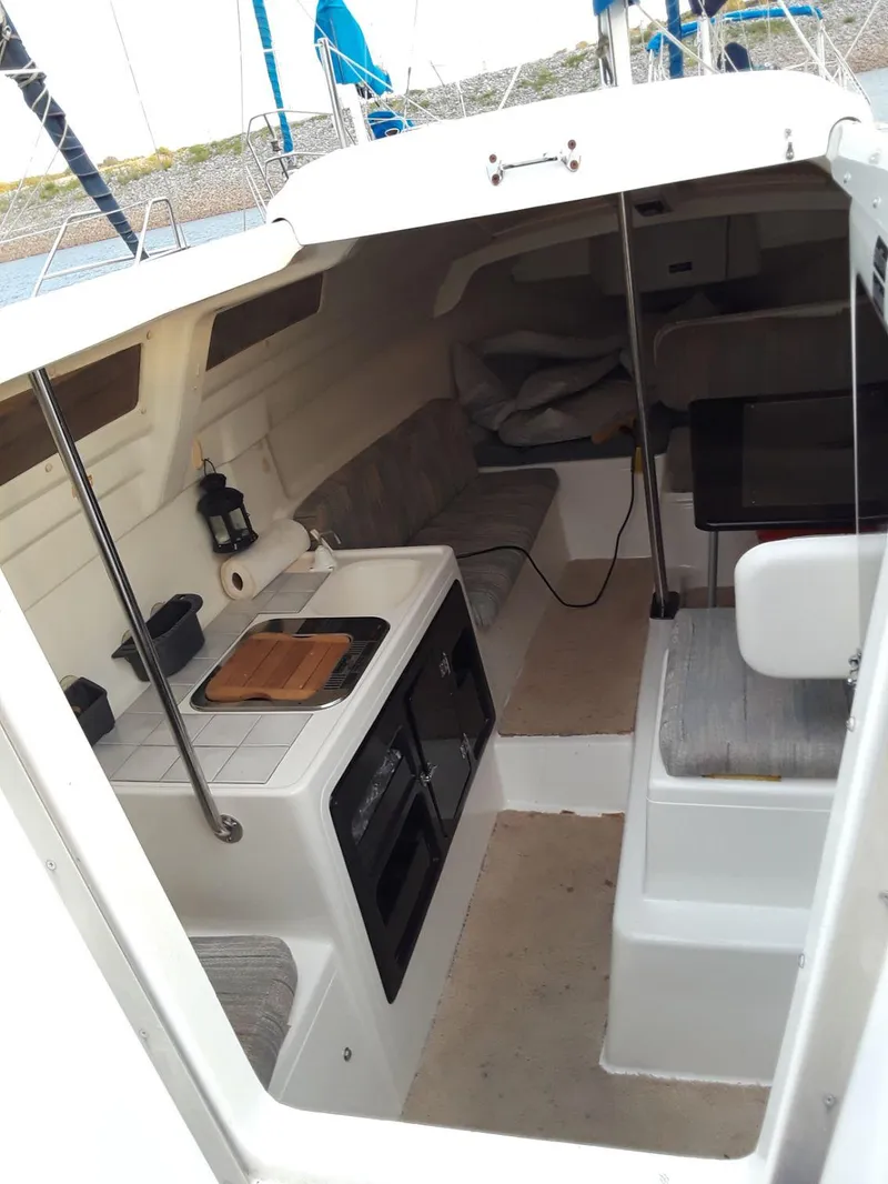 Slide: The Image of Interior of 1996 MacGregor 26 "X" sailboat with compact kitchen and seating area. - 4