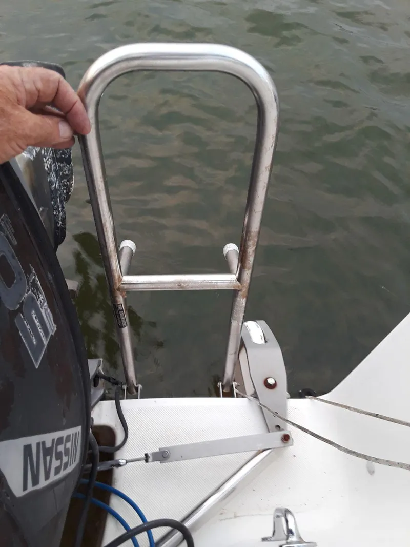 Slide: The Image of Stainless steel ladder on 1996 MacGregor 26 "X" sailboat near water. - 44