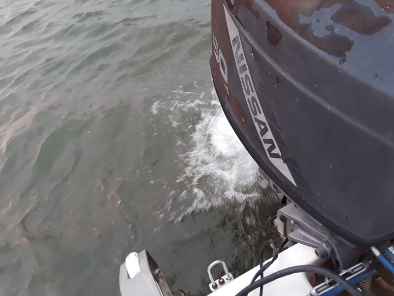 Slide: The Image of Outboard motor on a 1996 MacGregor 26 "X" sailboat in water. - 45