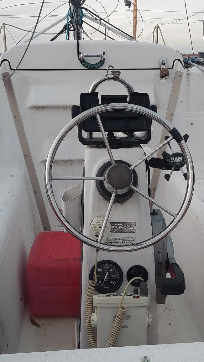 Slide: The Image of 1996 MacGregor 26 "X" sailboat cockpit with steering wheel and controls. - 49