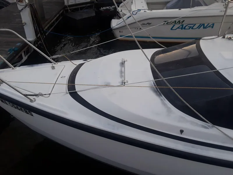 Slide: The Image of 1996 MacGregor 26 "X" sailboat docked, featuring sleek white design and rigging. - 9