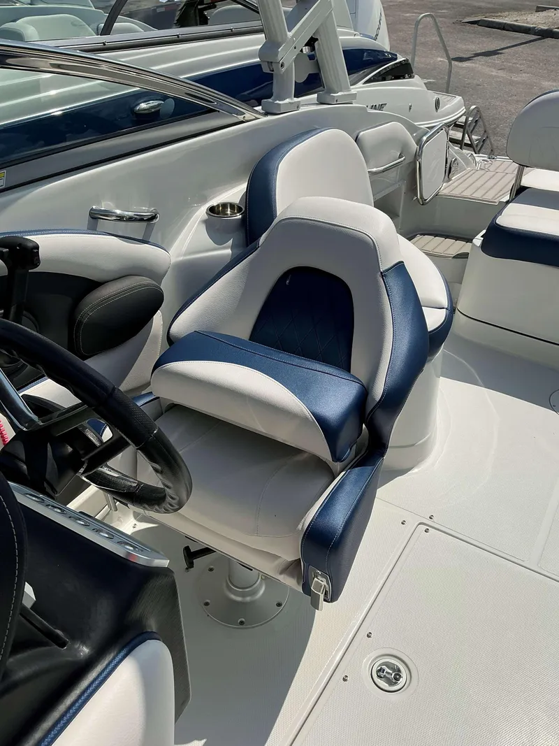 Slide: The Image of 2024 Crownline 260XSS boat interior with blue and white seating and steering wheel. - 10