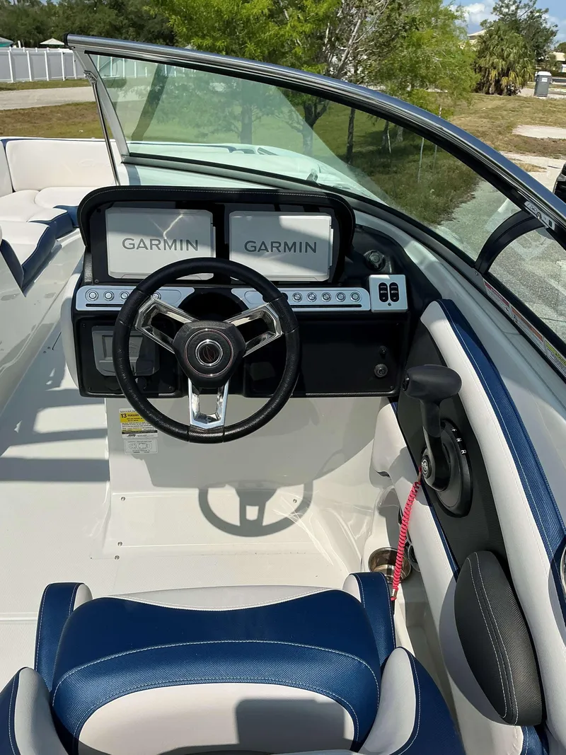 Slide: The Image of 2024 Crownline 260XSS boat dashboard with dual Garmin displays and steering wheel. - 13