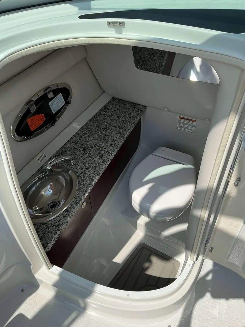 Slide: The Image of 2024 Crownline 260XSS boat interior bathroom with sink and toilet. - 16