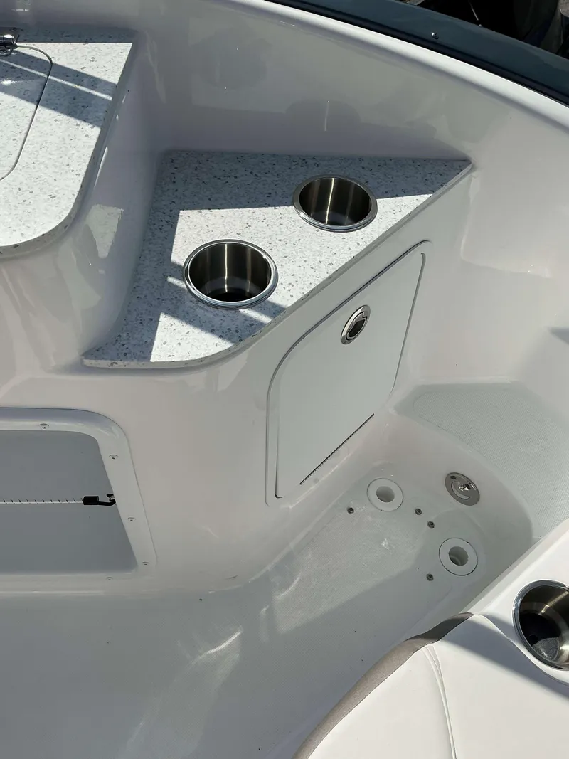 Slide: The Image of 2024 Crownline 260XSS boat interior with cup holders and storage compartment. - 18