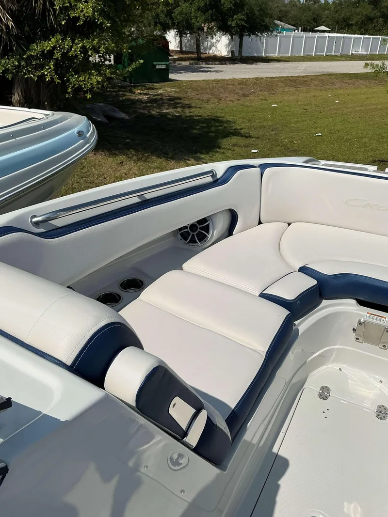 Slide: The Image of 2024 Crownline 260XSS boat interior with white and blue seating, cup holders, and speaker. - 5