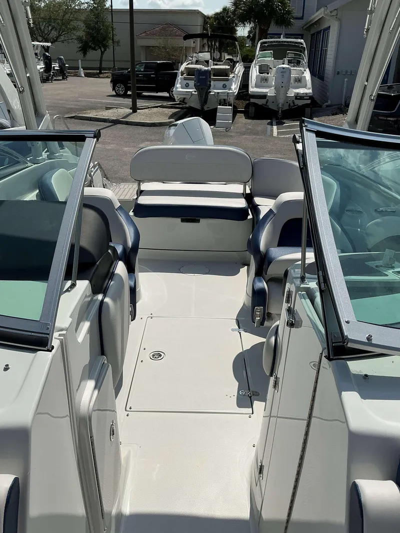 Slide: The Image of 2024 Crownline 260XSS boat interior with seating and windshield, docked outdoors. - 6