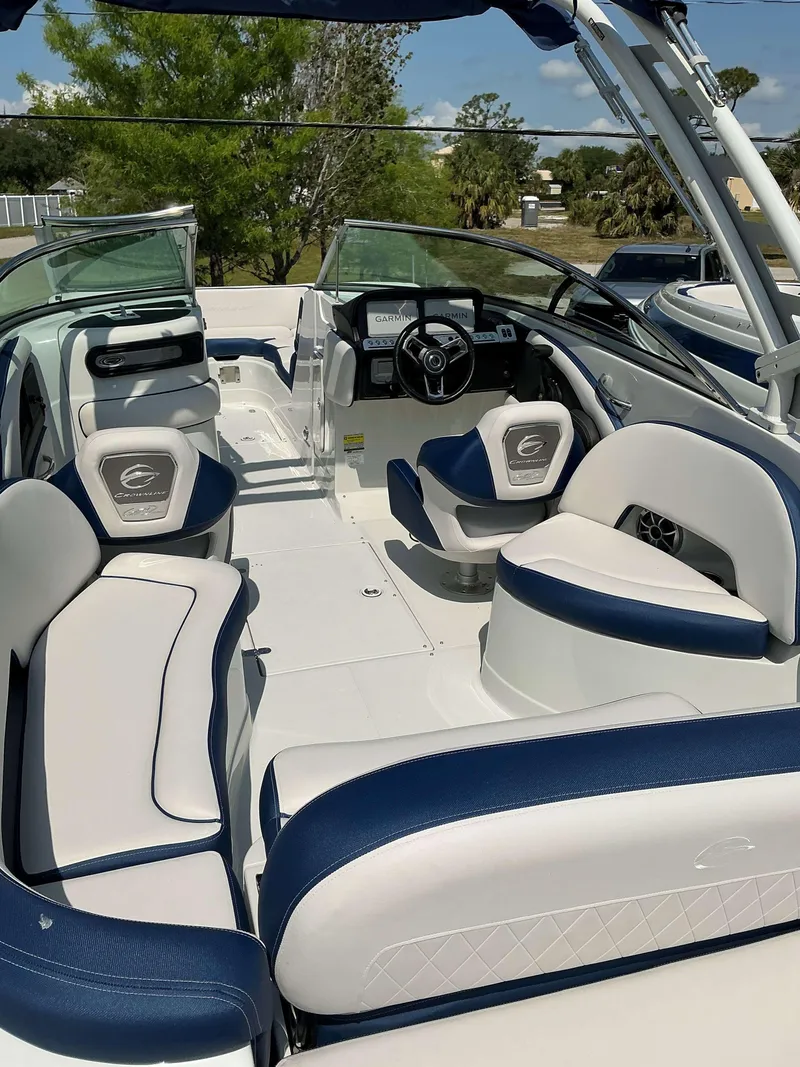 Slide: The Image of 2024 Crownline 260XSS boat interior with white and blue seating, steering wheel, and dashboard. - 7
