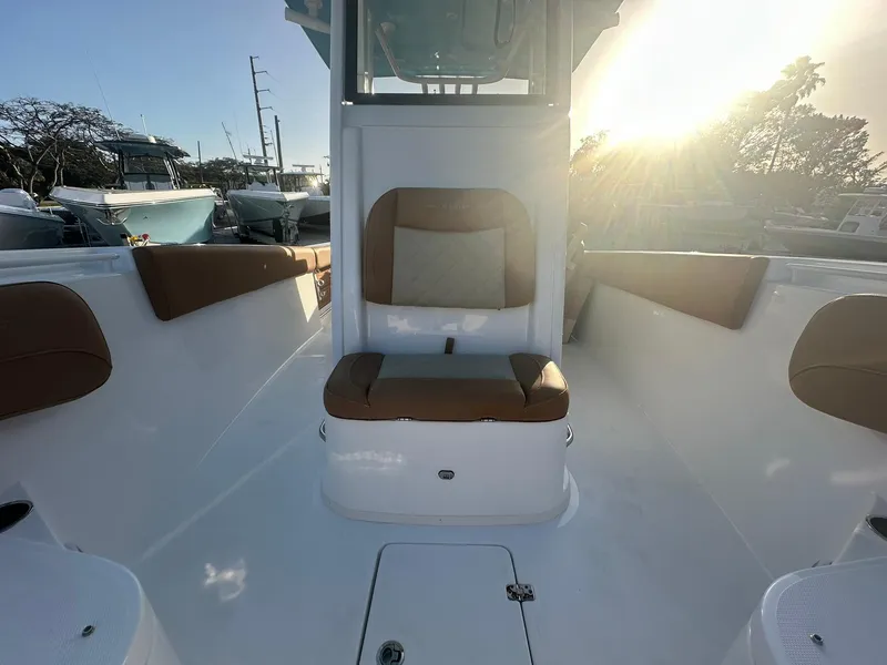 Slide: The Image of 2024 NauticStar 292 Legacy boat interior with cushioned seating and sunlight. - 11