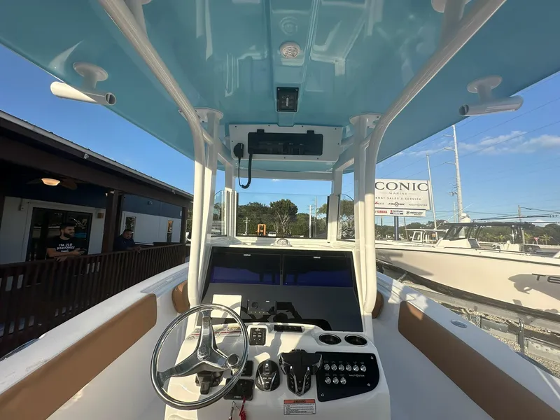 Slide: The Image of 2024 NauticStar 292 Legacy boat helm with modern controls and blue T-top. - 12