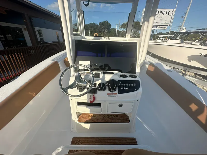 Slide: The Image of 2024 NauticStar 292 Legacy boat helm with steering wheel and control panel. - 13
