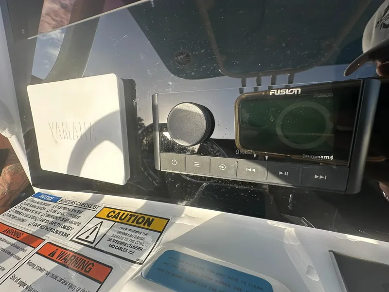 Slide: The Image of Close-up of the 2024 NauticStar 292 Legacy boat's control panel with Fusion audio system. - 16