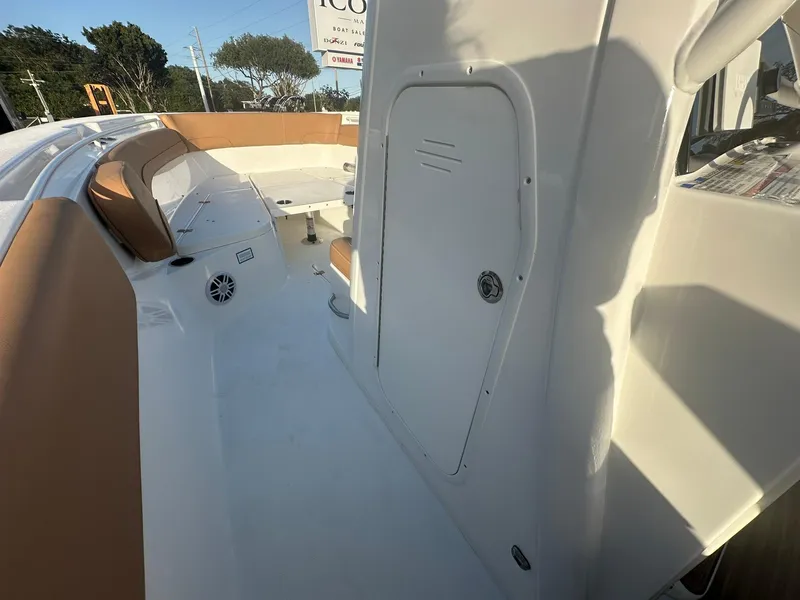 Slide: The Image of 2024 NauticStar 292 Legacy boat interior with tan seating and storage compartment. - 22