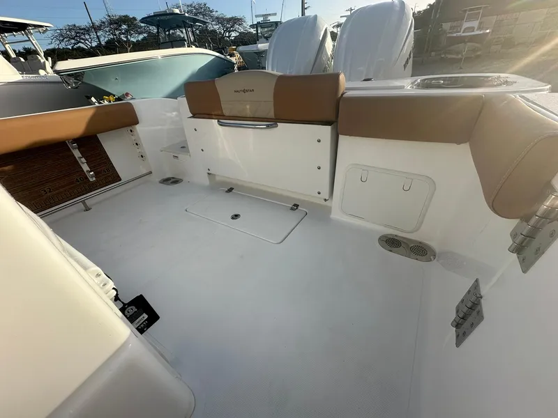Slide: The Image of 2024 NauticStar 292 Legacy boat interior with cushioned seating and storage compartments. - 30