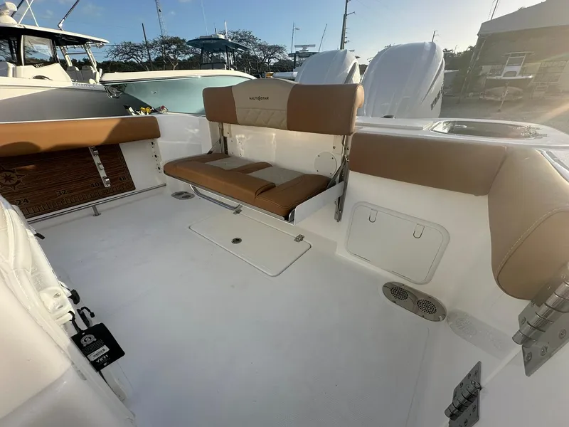 Slide: The Image of 2024 NauticStar 292 Legacy boat interior with tan seating and white deck. - 31