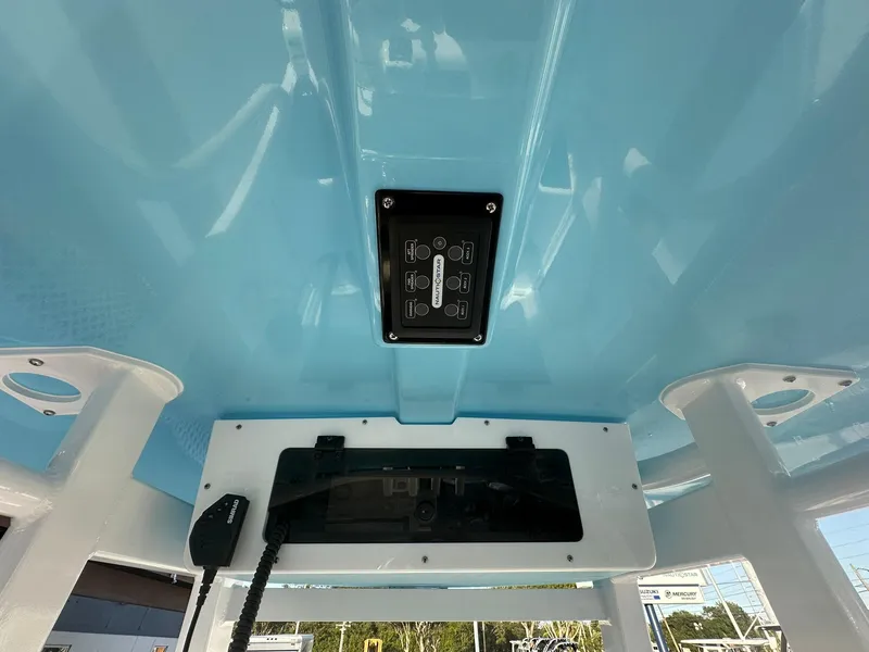 Slide: The Image of 2024 NauticStar 292 Legacy boat console with blue overhead panel and control switches. - 43
