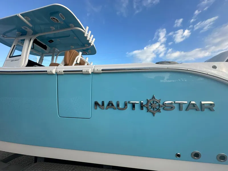 Slide: The Image of 2024 NauticStar 292 Legacy boat with blue hull and clear sky background. - 46