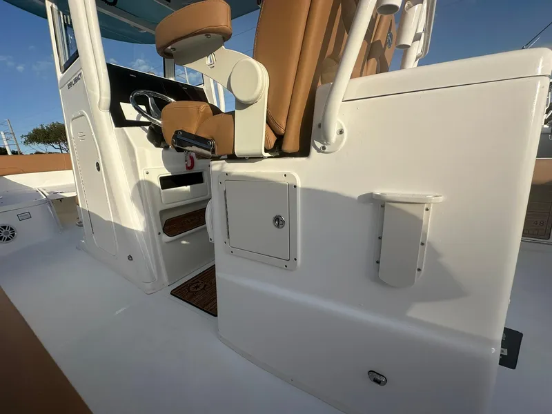 Slide: The Image of 2024 NauticStar 292 Legacy boat interior with brown seats and white console. - 47
