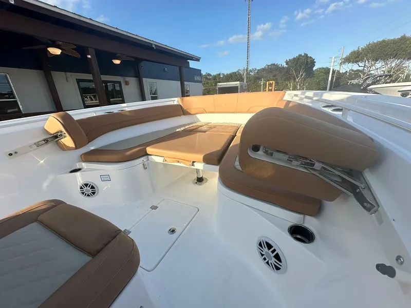 Slide: The Image of 2024 NauticStar 292 Legacy boat interior with tan seating and white deck. - 8