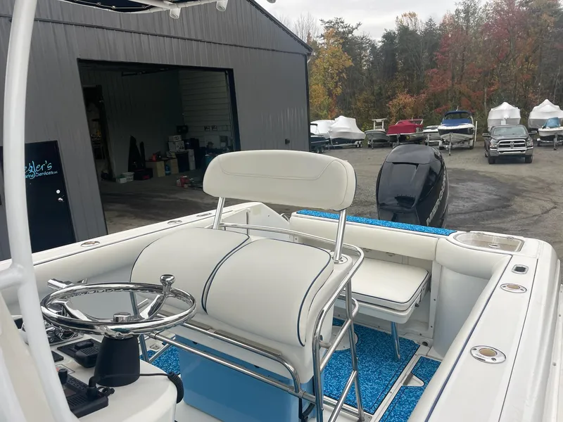 Slide: The Image of 2005 Boston Whaler Outrage 240 boat outdoors near a workshop. - 18