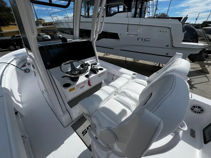 Slide: The Image of 2024 Sportsman Masters 247OE Bay Boat cockpit with steering wheel and seating. - 13