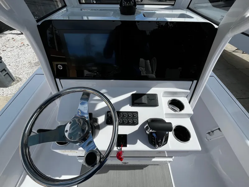 Slide: The Image of 2024 Sportsman Masters 247OE Bay Boat helm with steering wheel and control panel. - 14