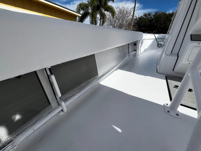 Slide: The Image of 2024 Sportsman Masters 247OE Bay Boat deck with storage compartments and clean white finish. - 17