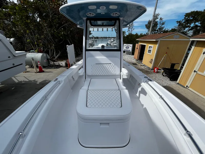 Slide: The Image of 2024 Sportsman Masters 247OE Bay Boat interior with cushioned seating and center console. - 22