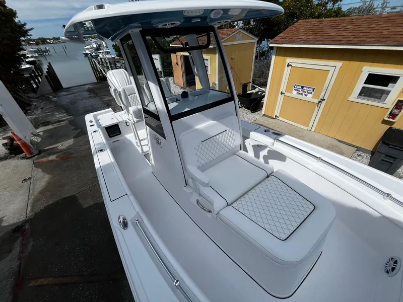 Slide: The Image of 2024 Sportsman Masters 247OE Bay Boat docked near yellow buildings. - 25