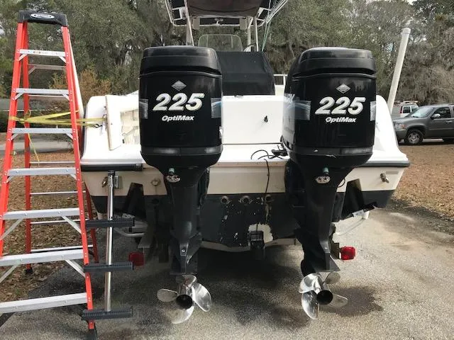 Slide: The Image of 2005 Mako 284 CC boat with twin 225 OptiMax engines, parked beside a ladder. - 4