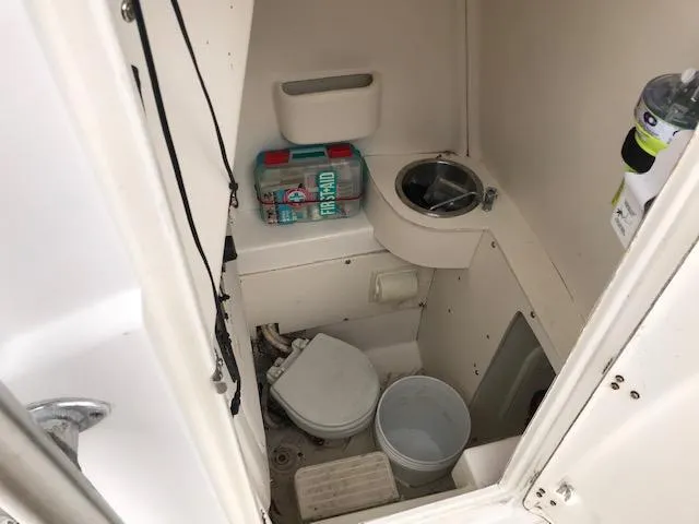 Slide: The Image of 2005 Mako 284 CC boat interior with compact bathroom and sink. - 8