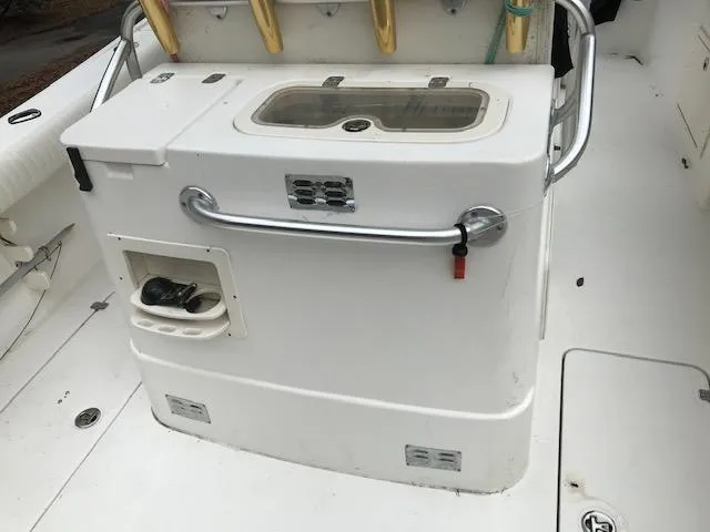 Slide: The Image of 2005 Mako 284 CC boat interior with fishing rod holders and storage compartments. - 9