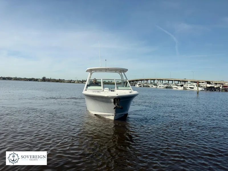 Slide: The Image of 2024 Blackfin 252 DC boat on calm water near a marina. - 11