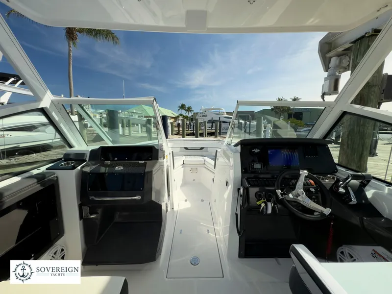 Slide: The Image of 2024 Blackfin 252 DC boat interior with helm and seating, docked at marina. - 17