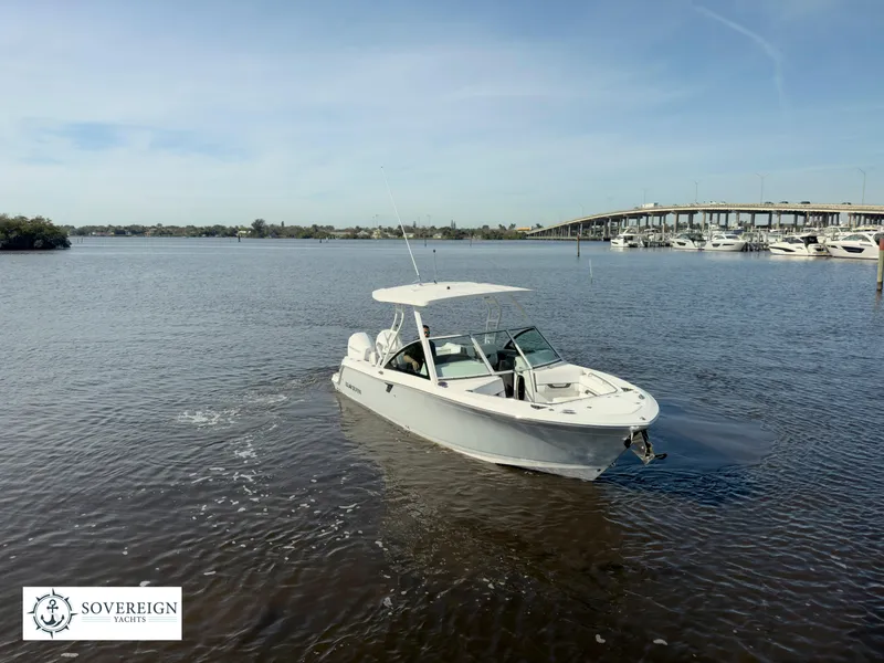 Slide: The Image of 2024 Blackfin 252 DC boat on calm waters near a bridge, Sovereign Yachts logo. - 2