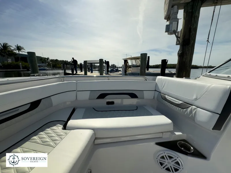 Slide: The Image of 2024 Blackfin 252 DC boat interior with white seating at a dock. - 21
