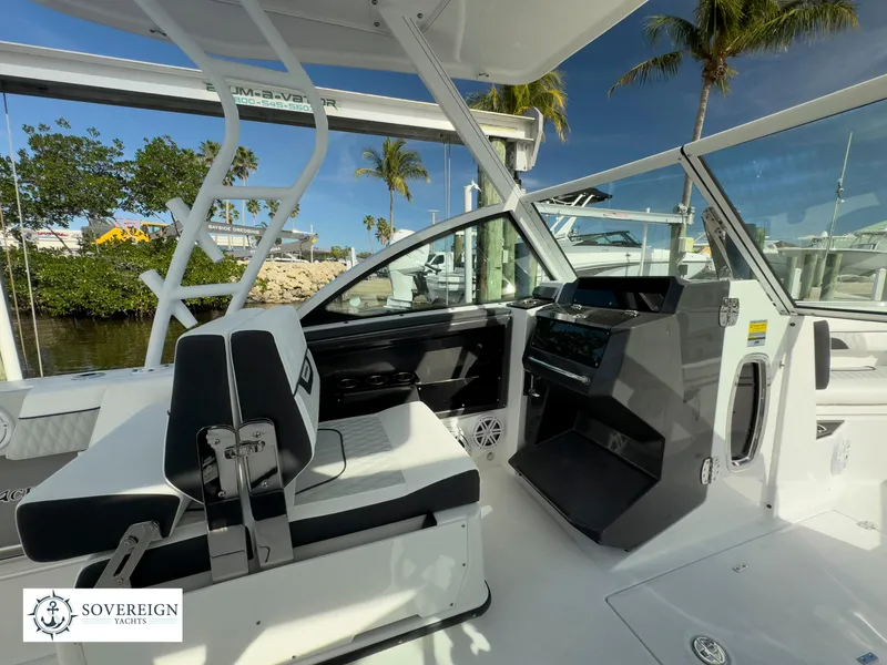 Slide: The Image of 2024 Blackfin 252 DC boat interior with helm station and seating, Sovereign Yachts logo. - 25