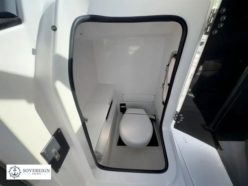Slide: The Image of 2024 Blackfin 252 DC boat interior bathroom with toilet and storage. - 28