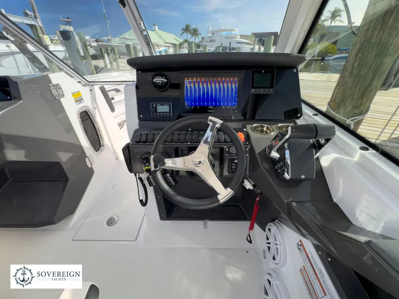 Slide: The Image of 2024 Blackfin 252 DC boat cockpit with steering wheel and control panel. - 35
