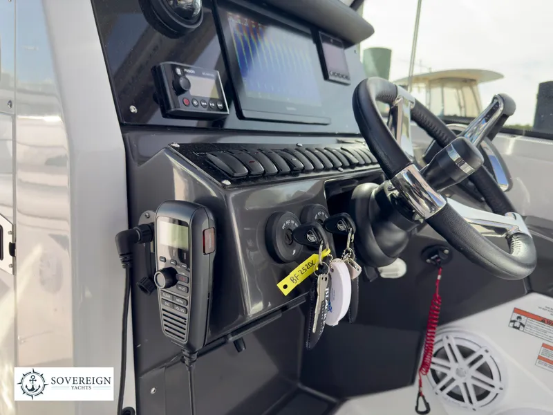 Slide: The Image of 2024 Blackfin 252 DC boat dashboard with steering wheel and control panel. Sovereign Yachts logo visible. - 39