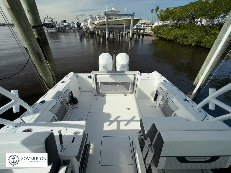 Slide: The Image of 2024 Blackfin 252 DC boat docked at a marina, showcasing spacious deck and twin engines. - 41